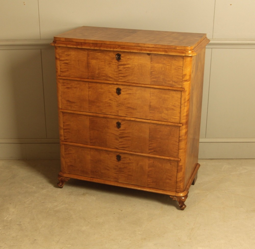A 19th-century Swedish chest of drawers crafted from flame birch veneer with four horizontal drawers, central dark escutcheons, and short carved bracket feet. View VIII