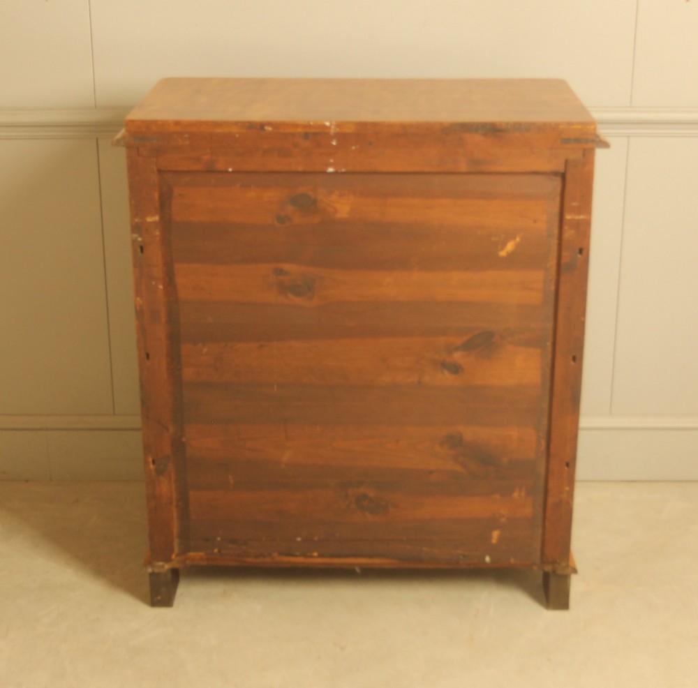 A 19th-century Swedish chest of drawers crafted from flame birch veneer with four horizontal drawers, central dark escutcheons, and short carved bracket feet. View X