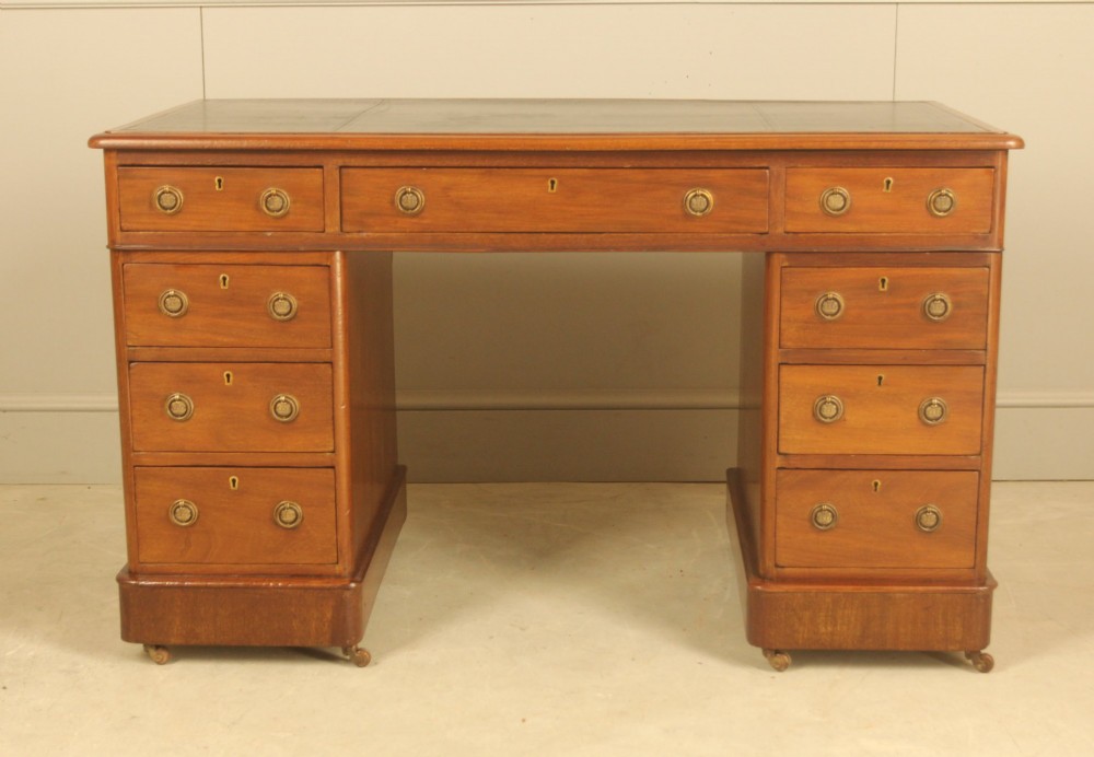 A Victorian mahogany pedestal desk featuring nine drawers with brass ring pulls and an inset leather writing top. View II