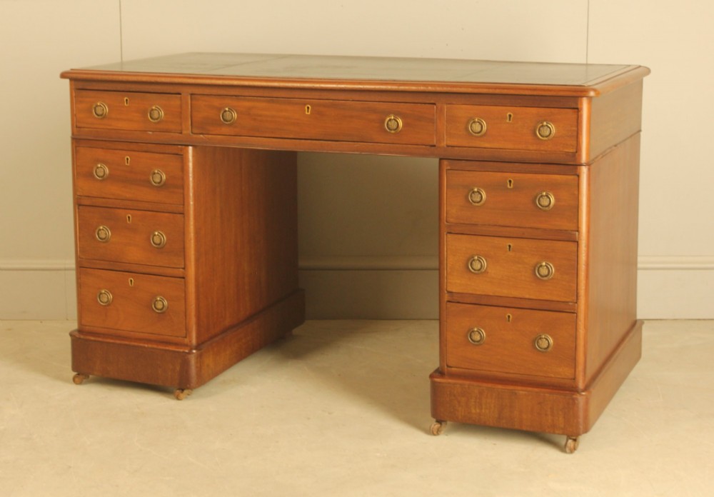 A Victorian mahogany pedestal desk featuring nine drawers with brass ring pulls and an inset leather writing top. View IV