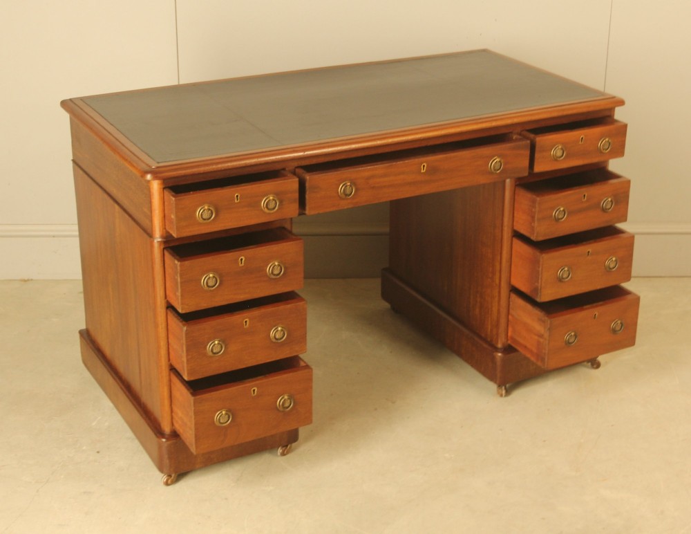 A Victorian mahogany pedestal desk featuring nine drawers with brass ring pulls and an inset leather writing top. View VII