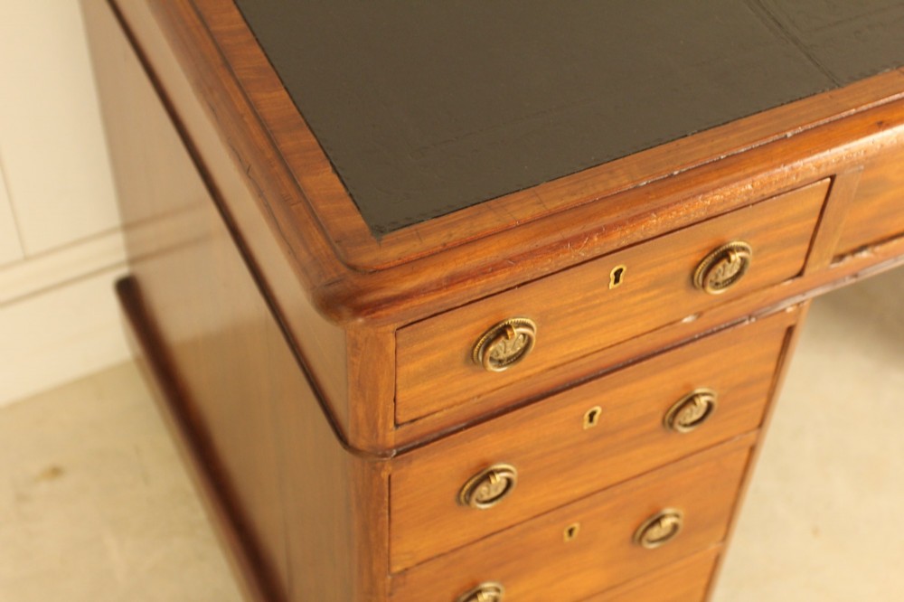 A Victorian mahogany pedestal desk featuring nine drawers with brass ring pulls and an inset leather writing top. View IX