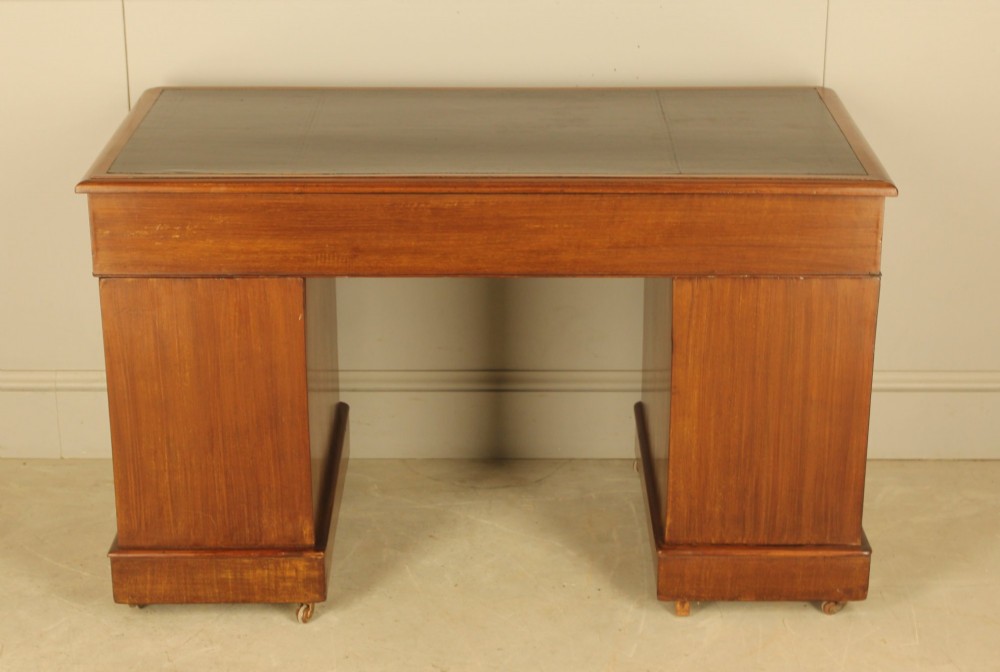 A Victorian mahogany pedestal desk featuring nine drawers with brass ring pulls and an inset leather writing top. View X
