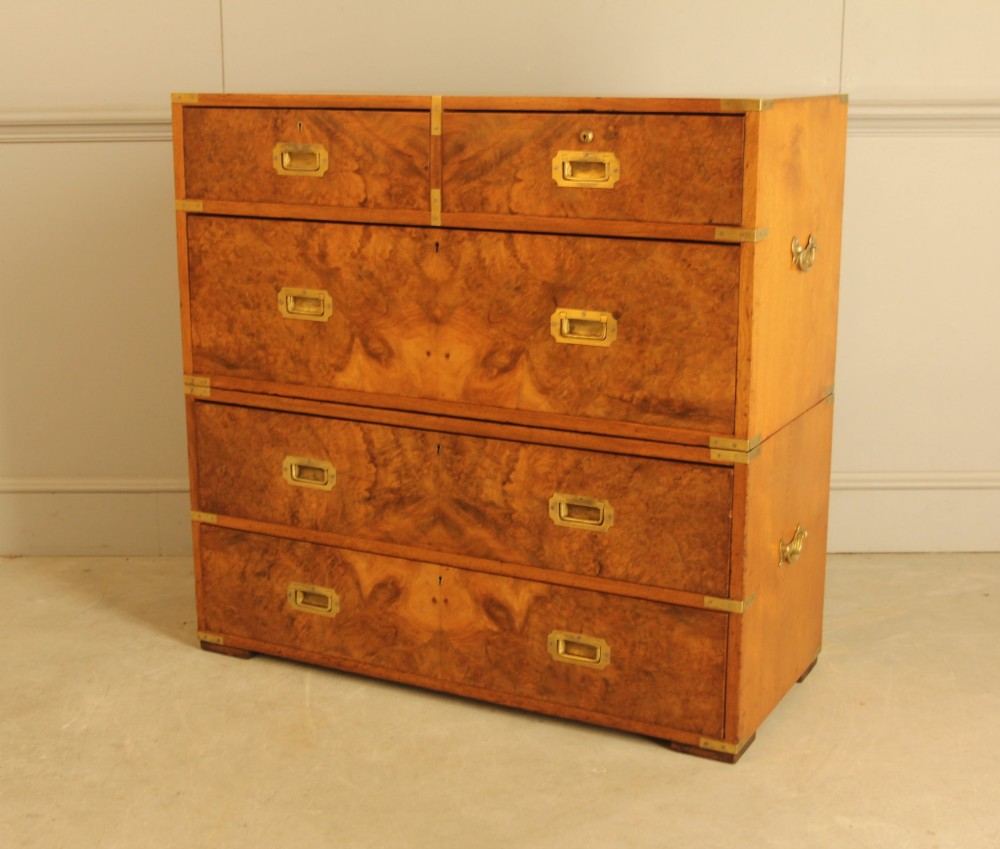 A Victorian burr walnut campaign chest of drawers featuring flush brass corner mounts, recessed drawer pulls, and side carrying handles.