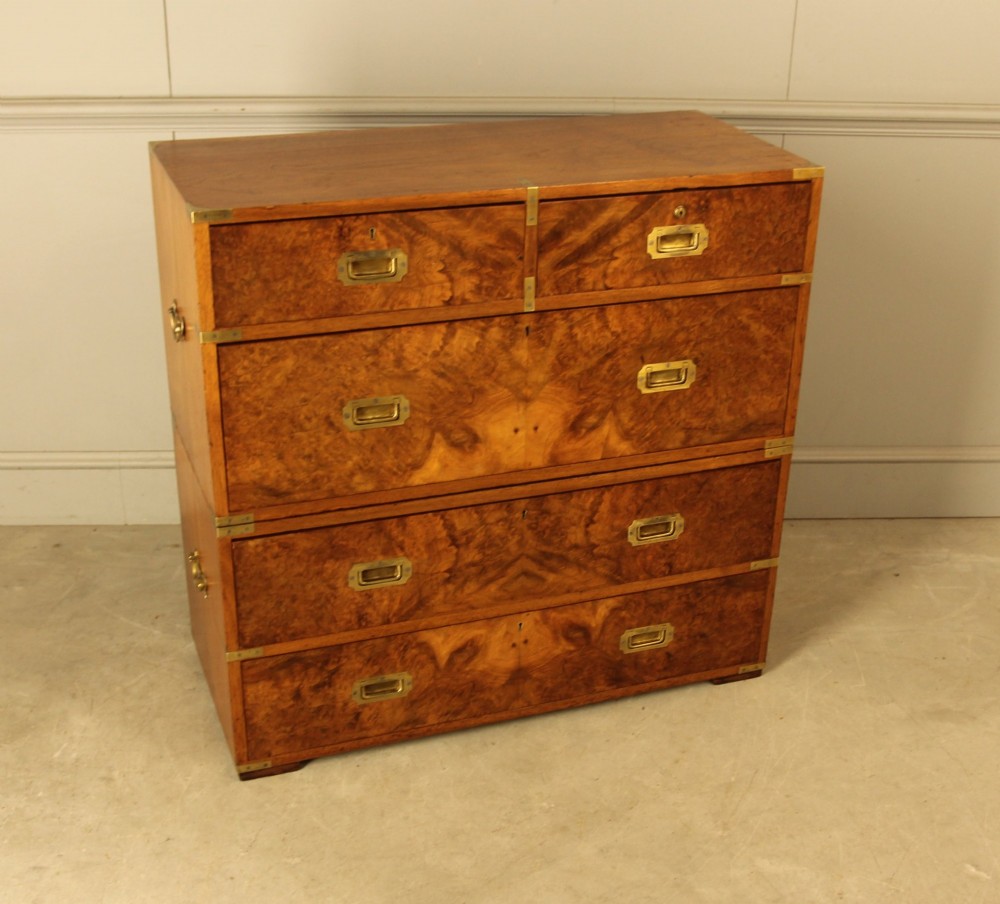A Victorian burr walnut campaign chest of drawers featuring flush brass corner mounts, recessed drawer pulls, and side carrying handles. View V
