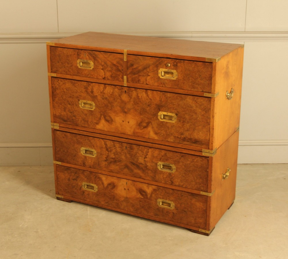 A Victorian burr walnut campaign chest of drawers featuring flush brass corner mounts, recessed drawer pulls, and side carrying handles. View VI