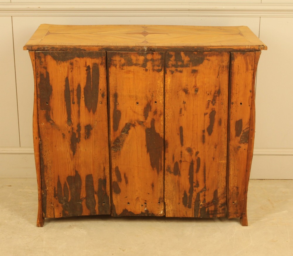 An 18th-century Swedish Rococo bombe chest of drawers featuring geometric chevron parquetry inlays, curved sides, three long drawers, and cast brass hardware. View XIII