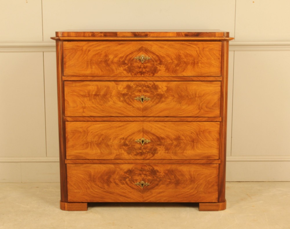 A 19th-century Swedish chest of drawers in warm curl mahogany featuring book-matched veneer, brass escutcheons, and a clean rectangular silhouette.