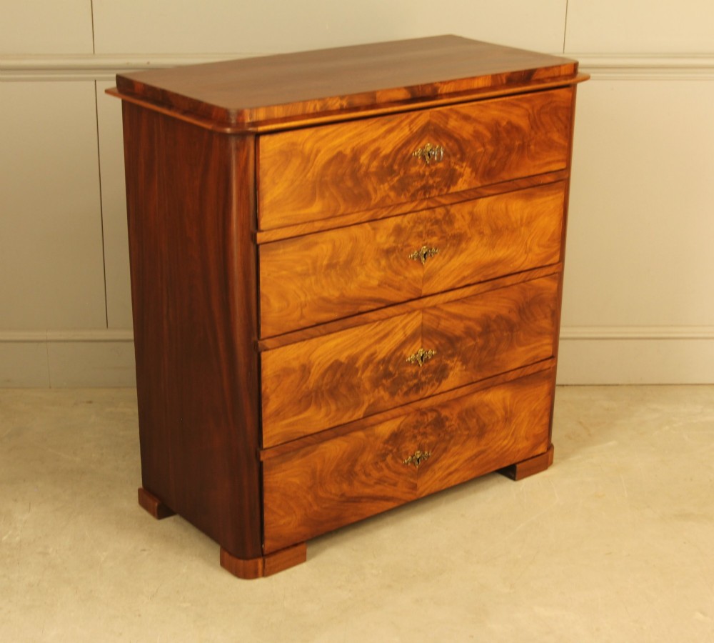 A 19th-century Swedish chest of drawers in warm curl mahogany featuring book-matched veneer, brass escutcheons, and a clean rectangular silhouette. View VI