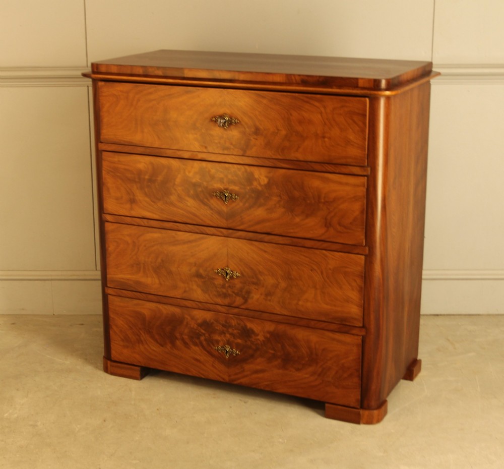 A 19th-century Swedish chest of drawers in warm curl mahogany featuring book-matched veneer, brass escutcheons, and a clean rectangular silhouette. View VII
