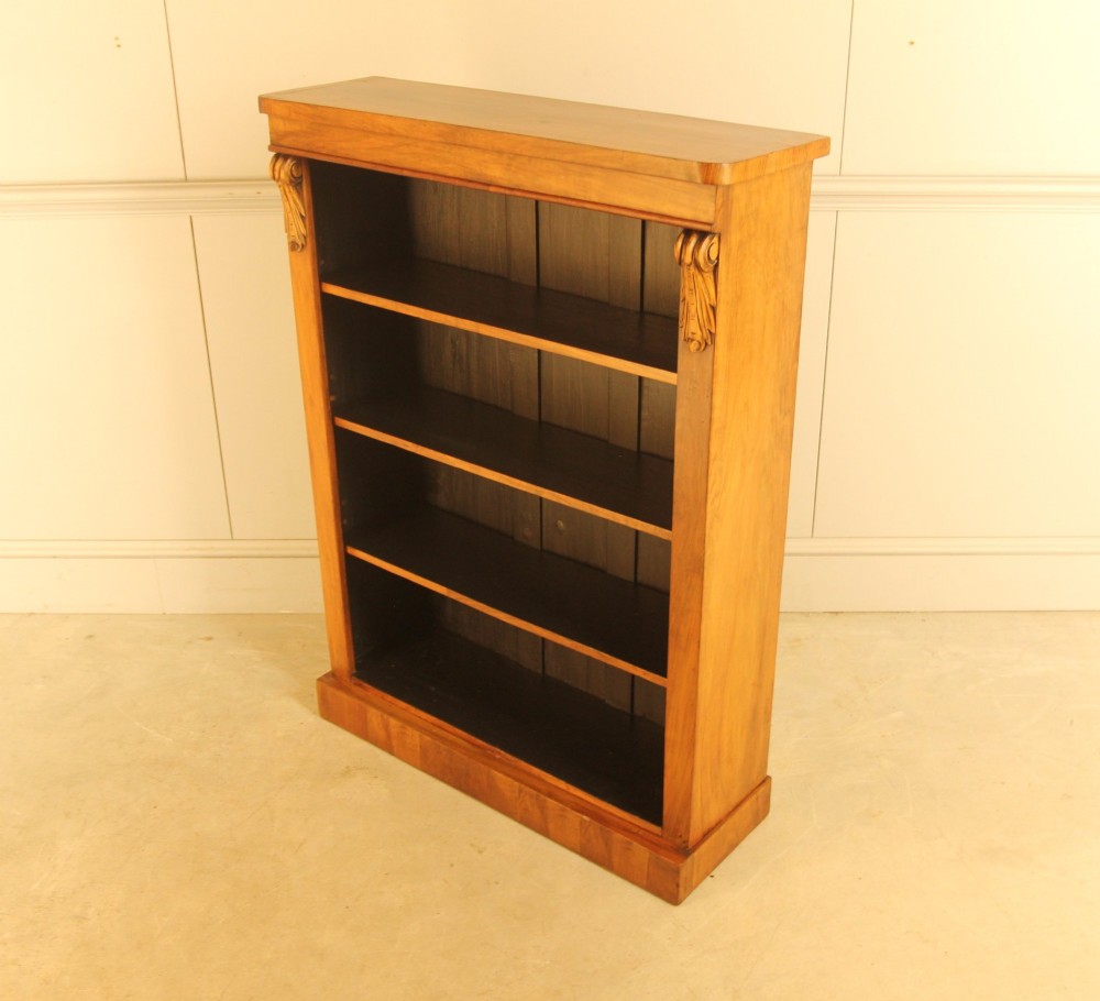 A Victorian walnut open bookcase featuring four horizontal shelves, carved decorative corbels at the upper corners, and a dark painted backboard. View VIII
