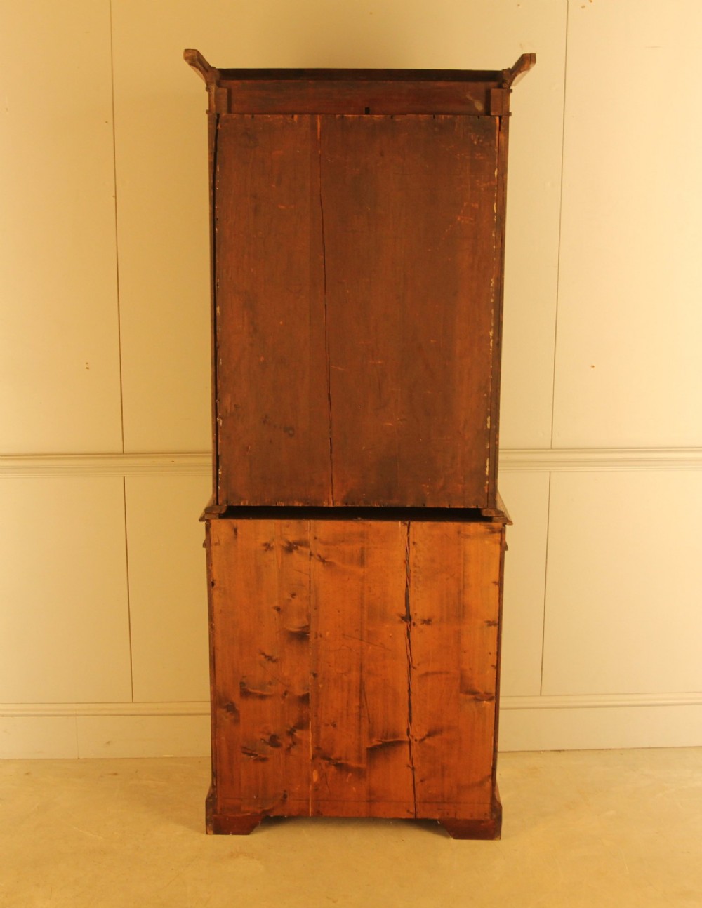 A two-door 19th-century mahogany bookcase featuring an upper glazed display section with internal shelves above a lower cabinet with flame mahogany panelled doors. View VIII