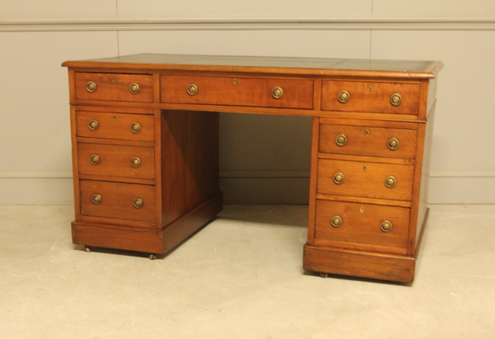 A Victorian walnut pedestal desk featuring nine drawers with brass handles and a dark leather writing inset top. View VIII