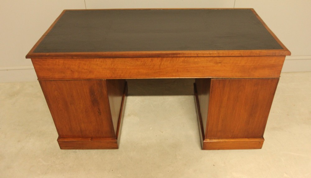 A Victorian walnut pedestal desk featuring nine drawers with brass handles and a dark leather writing inset top. View IX