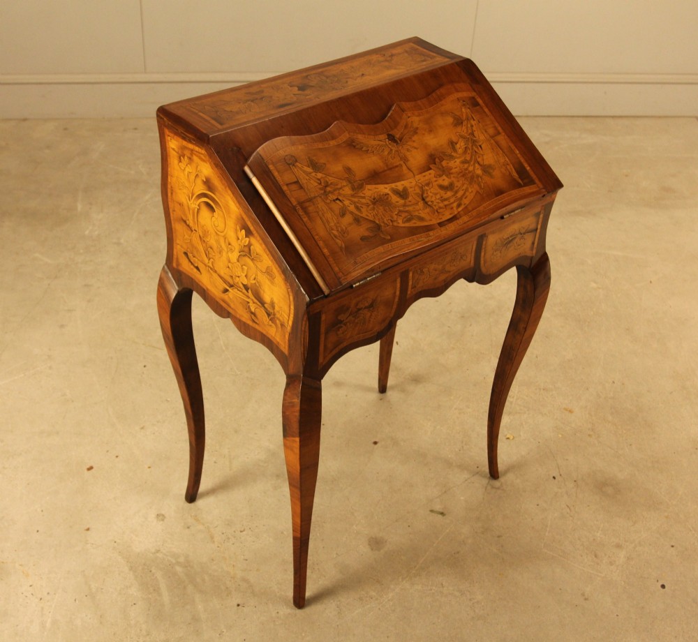 A 19th-century Italian walnut writing bureau featuring floral marquetry inlay, a slanted fall front, and slender cabriole legs. View IV