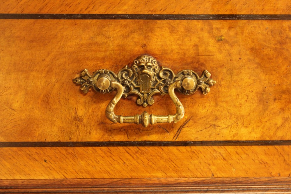 A tall 19th-century Swedish burr walnut chest of drawers featuring seven drawers, crossbanded inlay, ornate brass handles, and a stepped top section. View VII