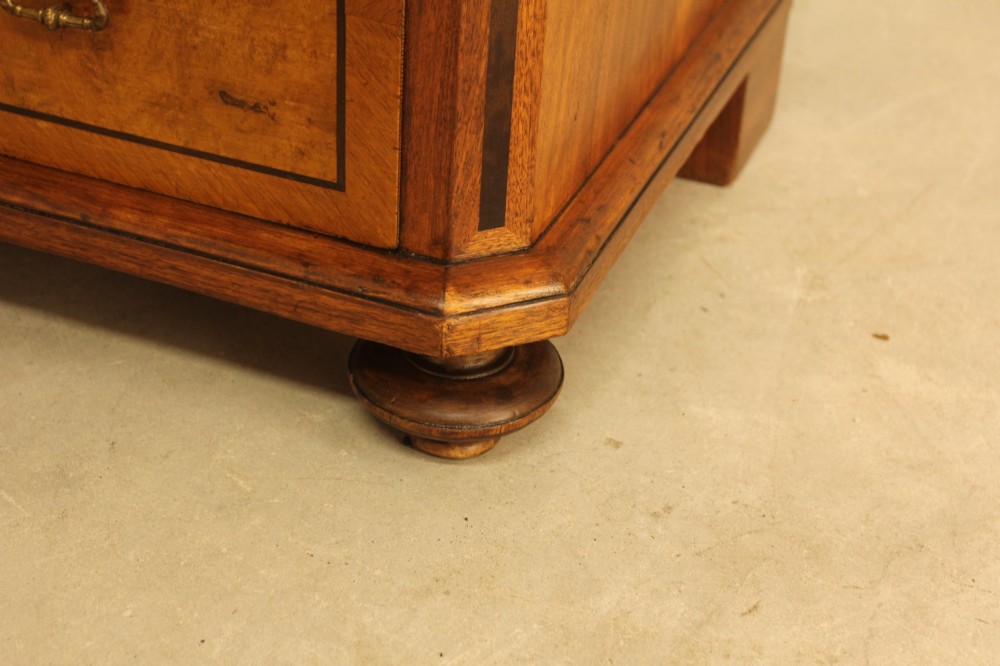 A tall 19th-century Swedish burr walnut chest of drawers featuring seven drawers, crossbanded inlay, ornate brass handles, and a stepped top section. View IX
