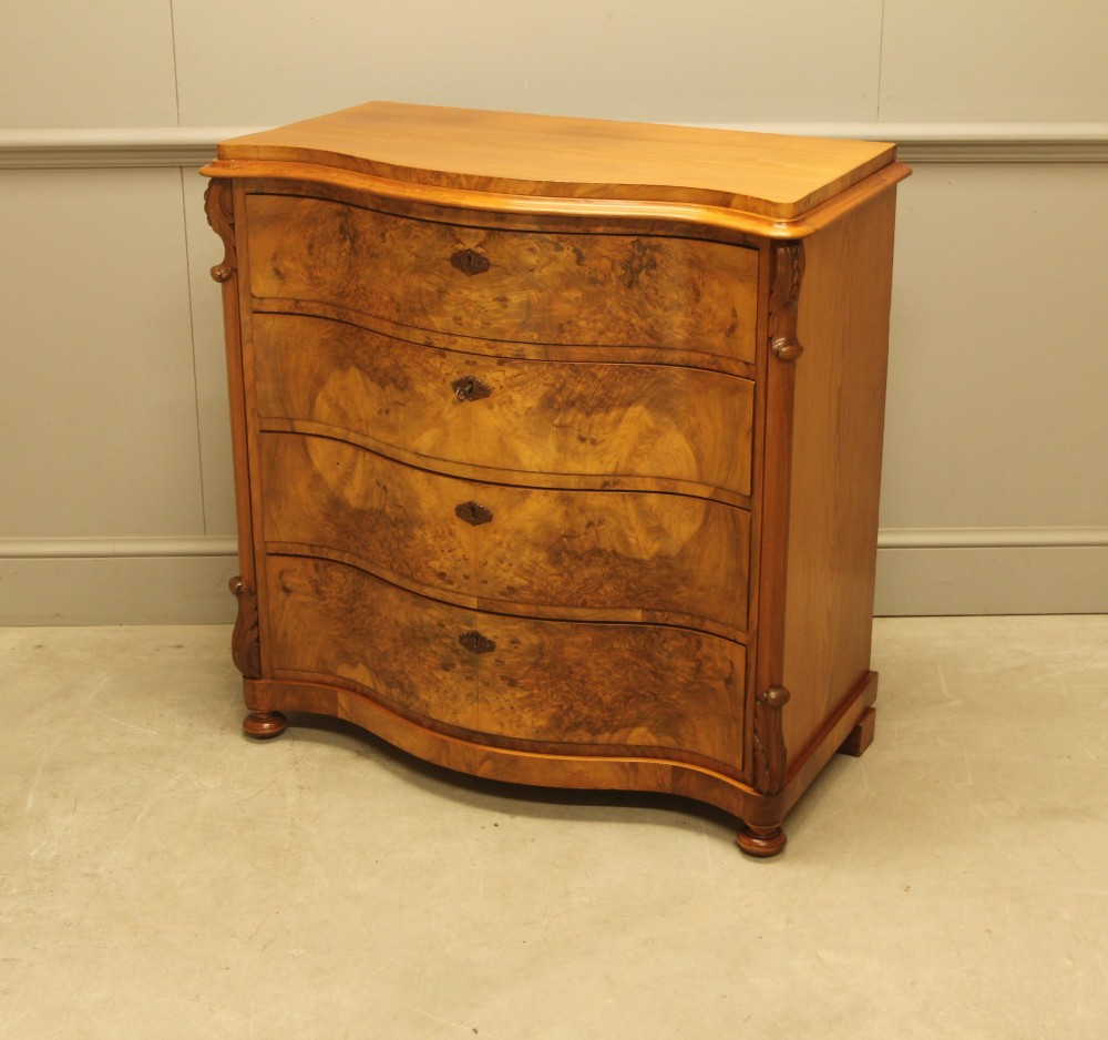 A 19th-century Swedish burr walnut chest of drawers featuring a serpentine front, four graduated drawers, brass escutcheons, and carved side pilasters. View VIII
