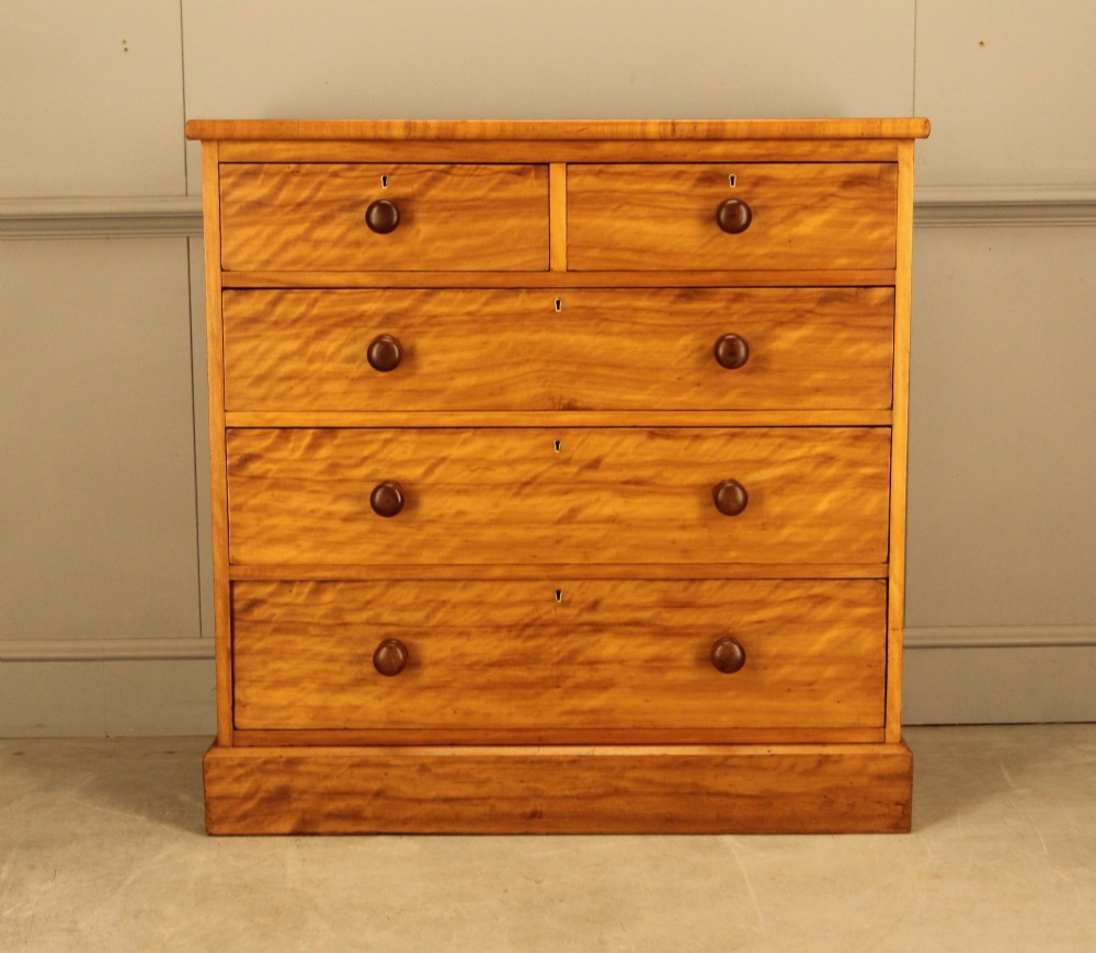 A Victorian stained birch chest of drawers featuring a two short over three long drawer configuration with turned wooden knobs and a solid plinth base. View II