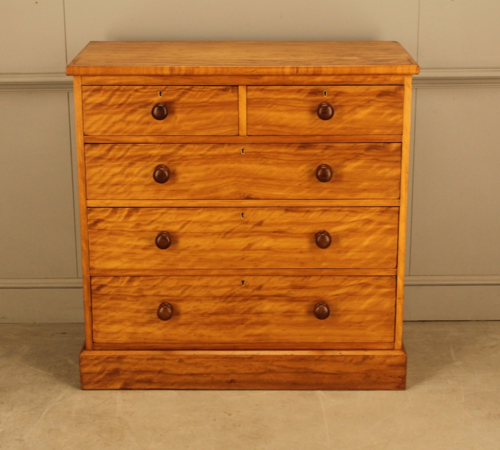 A Victorian stained birch chest of drawers featuring a two short over three long drawer configuration with turned wooden knobs and a solid plinth base. View IV