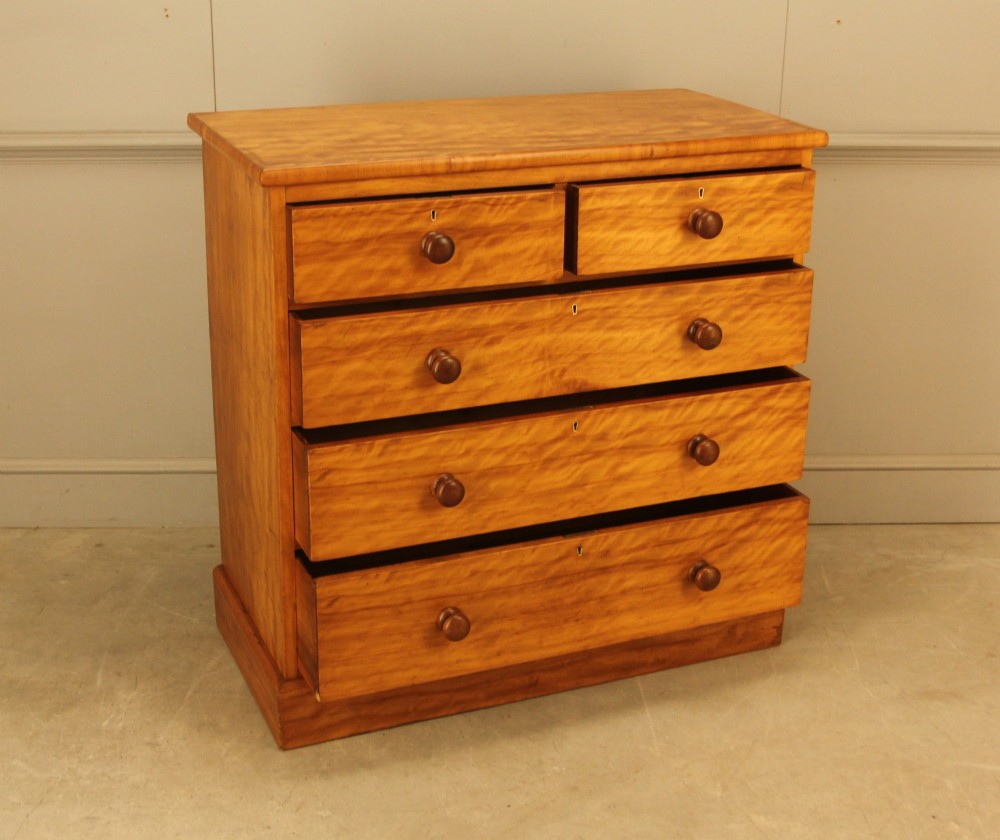A Victorian stained birch chest of drawers featuring a two short over three long drawer configuration with turned wooden knobs and a solid plinth base. View VIII
