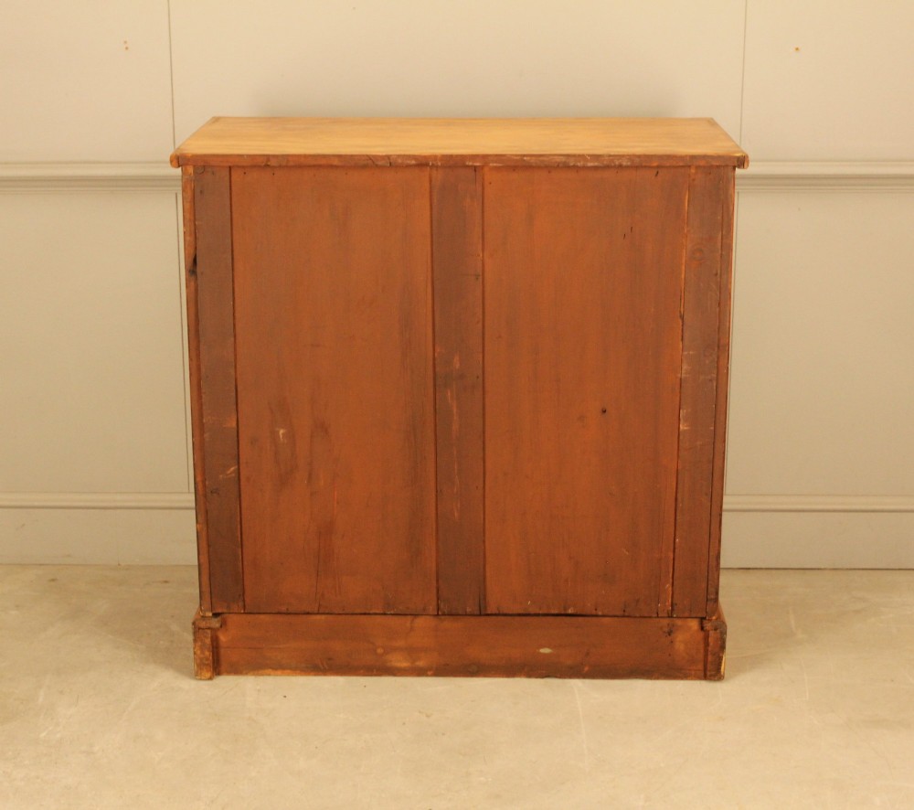 A Victorian stained birch chest of drawers featuring a two short over three long drawer configuration with turned wooden knobs and a solid plinth base. View X