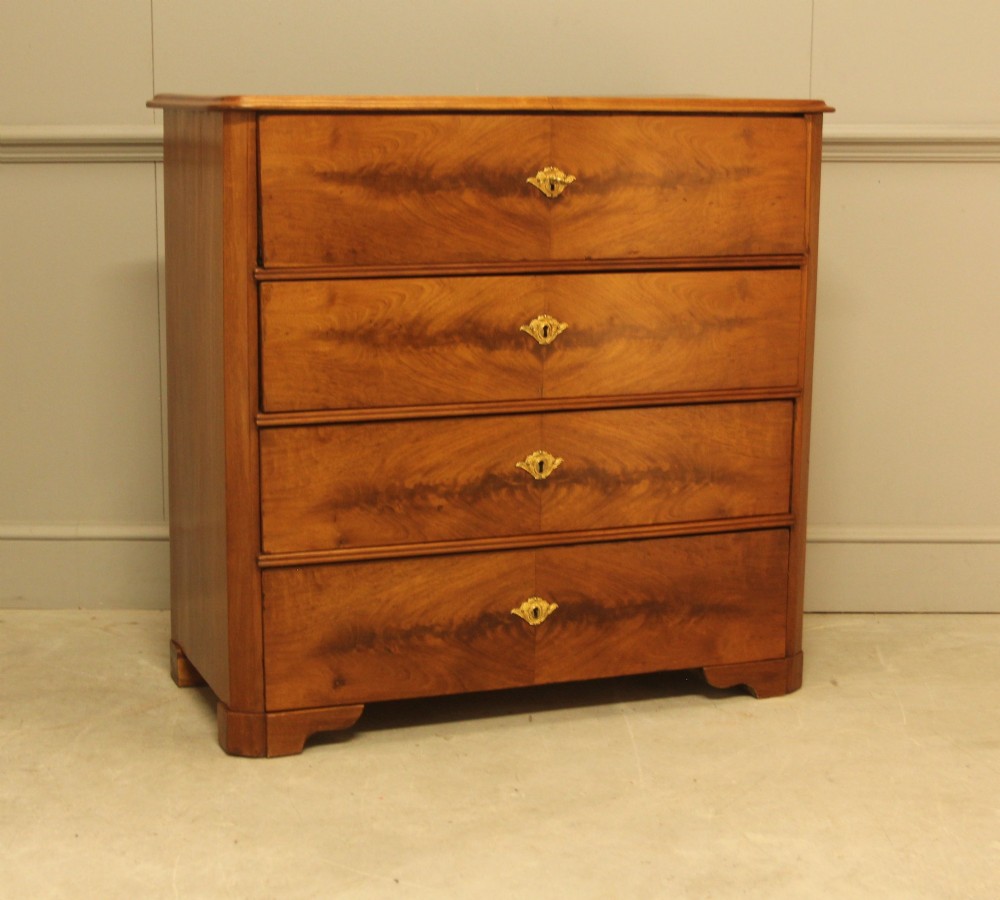 A nineteenth-century Swedish curl mahogany secretaire chest featuring three long drawers below a fold-down desk surface revealing fitted interior drawers. View III