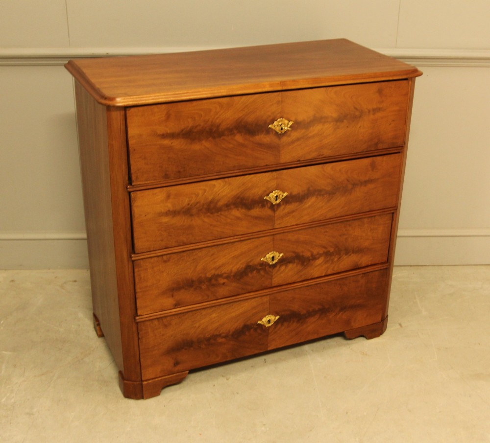 A nineteenth-century Swedish curl mahogany secretaire chest featuring three long drawers below a fold-down desk surface revealing fitted interior drawers. View VII