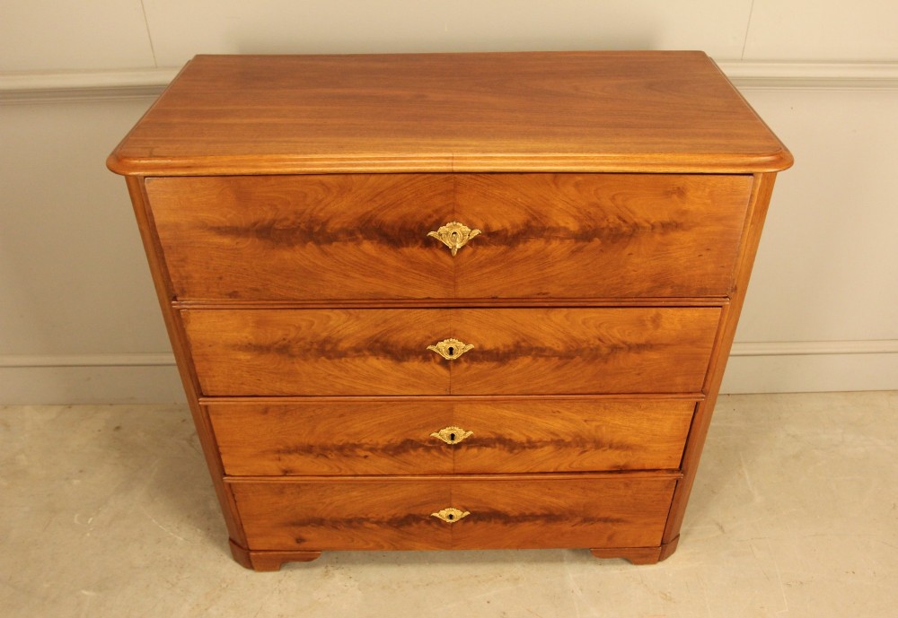 A nineteenth-century Swedish curl mahogany secretaire chest featuring three long drawers below a fold-down desk surface revealing fitted interior drawers. View VIII