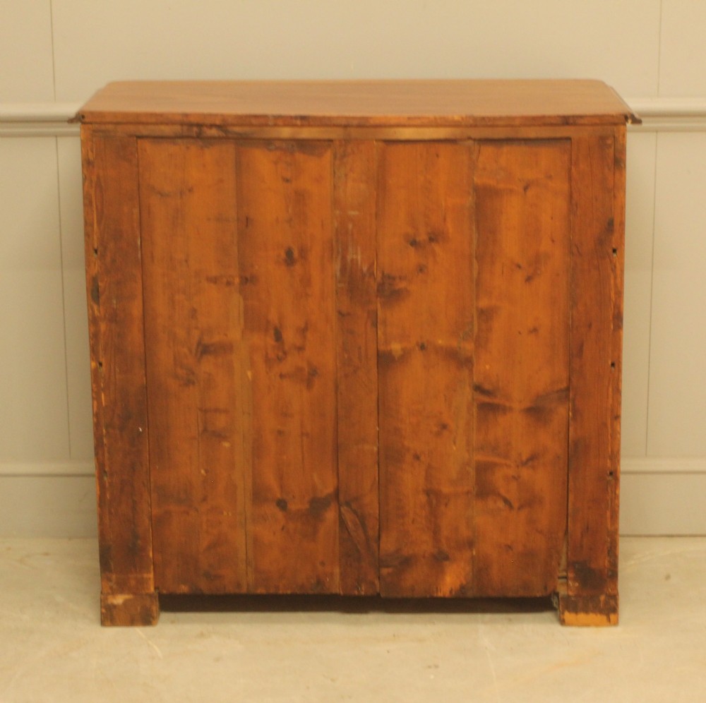 A nineteenth-century Swedish curl mahogany secretaire chest featuring three long drawers below a fold-down desk surface revealing fitted interior drawers. View X