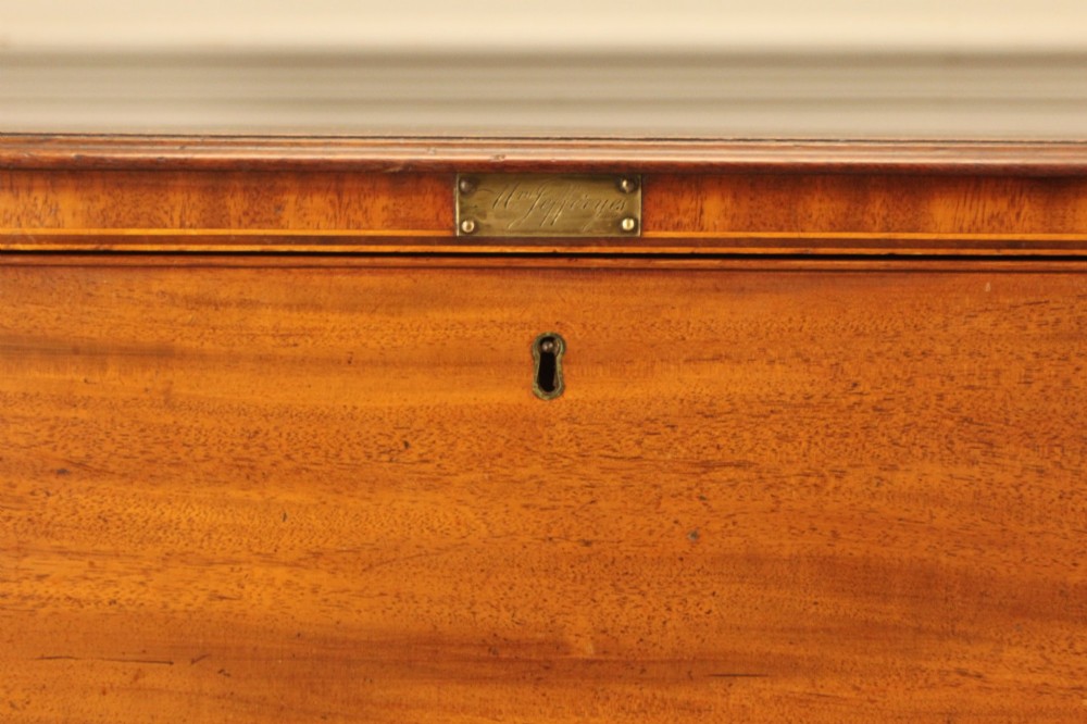 A Regency mahogany chest of drawers featuring three graduated drawers with brass turned knobs and reeded side pilasters resting on turned feet. View IX