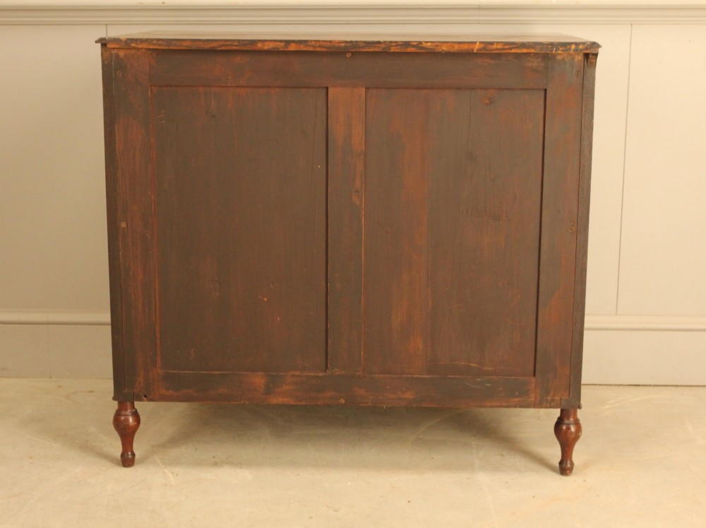 A Regency mahogany chest of drawers featuring three graduated drawers with brass turned knobs and reeded side pilasters resting on turned feet. View X