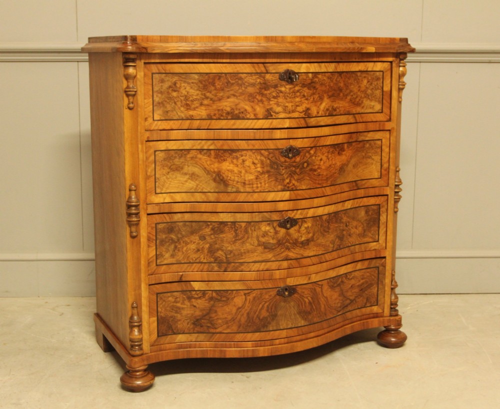 A 19th-century Swedish burr walnut chest featuring four serpentine-front drawers, bookmatched veneers, turned side pilasters, and bun feet. View II