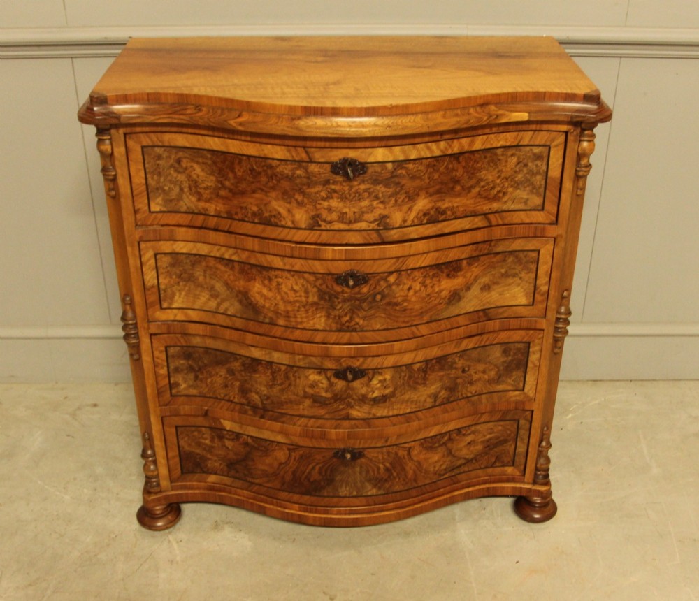 A 19th-century Swedish burr walnut chest featuring four serpentine-front drawers, bookmatched veneers, turned side pilasters, and bun feet. View IV
