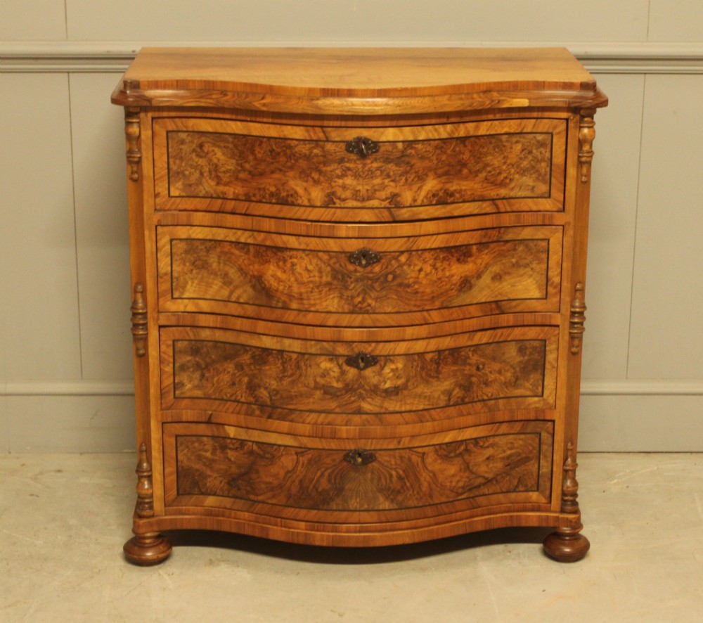 A 19th-century Swedish burr walnut chest featuring four serpentine-front drawers, bookmatched veneers, turned side pilasters, and bun feet. View VII