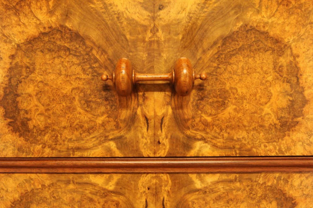 A tall 19th-century Swedish Wellington chest featuring six book-matched burr walnut drawers with turned handles, flanked by carved pilasters. View XI
