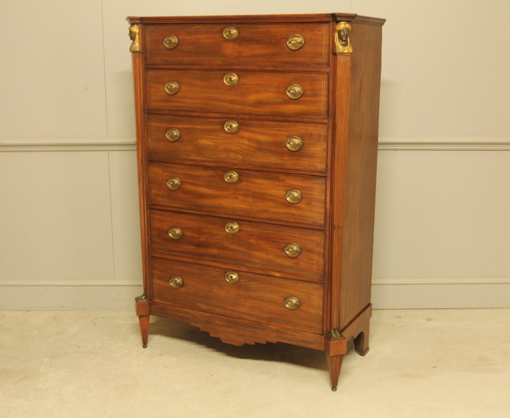 A French 19th-century mahogany tallboy chest of drawers featuring six drawers, brass ring handles, escutcheons, and fluted side pilasters topped with brass busts. View III