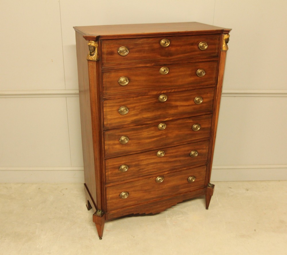 A French 19th-century mahogany tallboy chest of drawers featuring six drawers, brass ring handles, escutcheons, and fluted side pilasters topped with brass busts. View VII