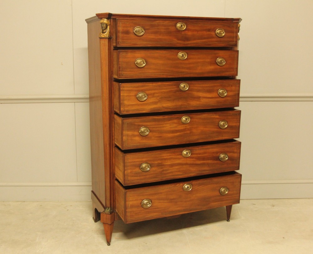 A French 19th-century mahogany tallboy chest of drawers featuring six drawers, brass ring handles, escutcheons, and fluted side pilasters topped with brass busts. View IX