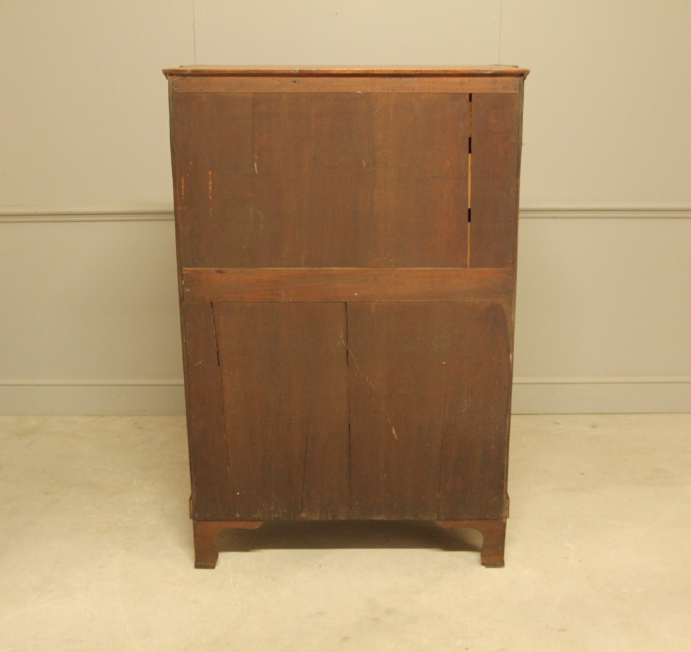 A French 19th-century mahogany tallboy chest of drawers featuring six drawers, brass ring handles, escutcheons, and fluted side pilasters topped with brass busts. View XI