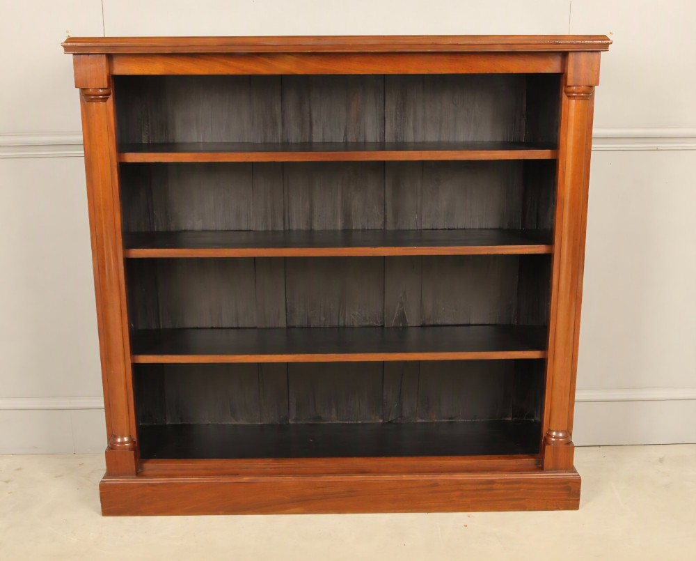 A Victorian open mahogany bookcase featuring four shelves flanked by turned pilasters on a solid plinth base. View II