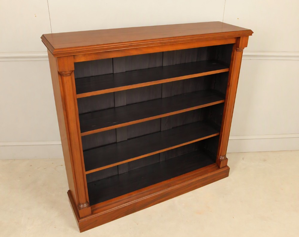 A Victorian open mahogany bookcase featuring four shelves flanked by turned pilasters on a solid plinth base. View V