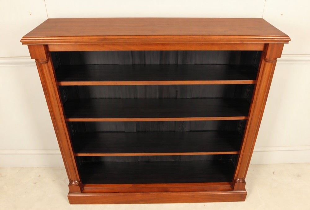 A Victorian open mahogany bookcase featuring four shelves flanked by turned pilasters on a solid plinth base. View VI