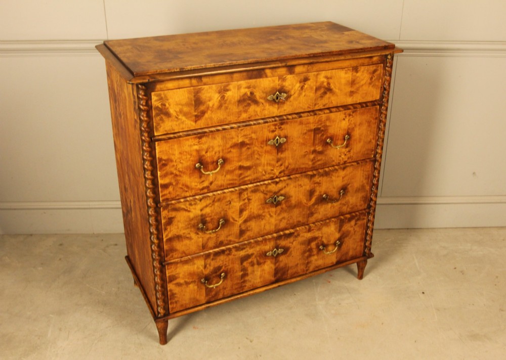 A nineteenth-century Swedish chest of drawers crafted from highly figured flame birch veneer, featuring four full-width drawers with brass drop handles, brass escutcheons, and spiral-twisted side columns. View VIII