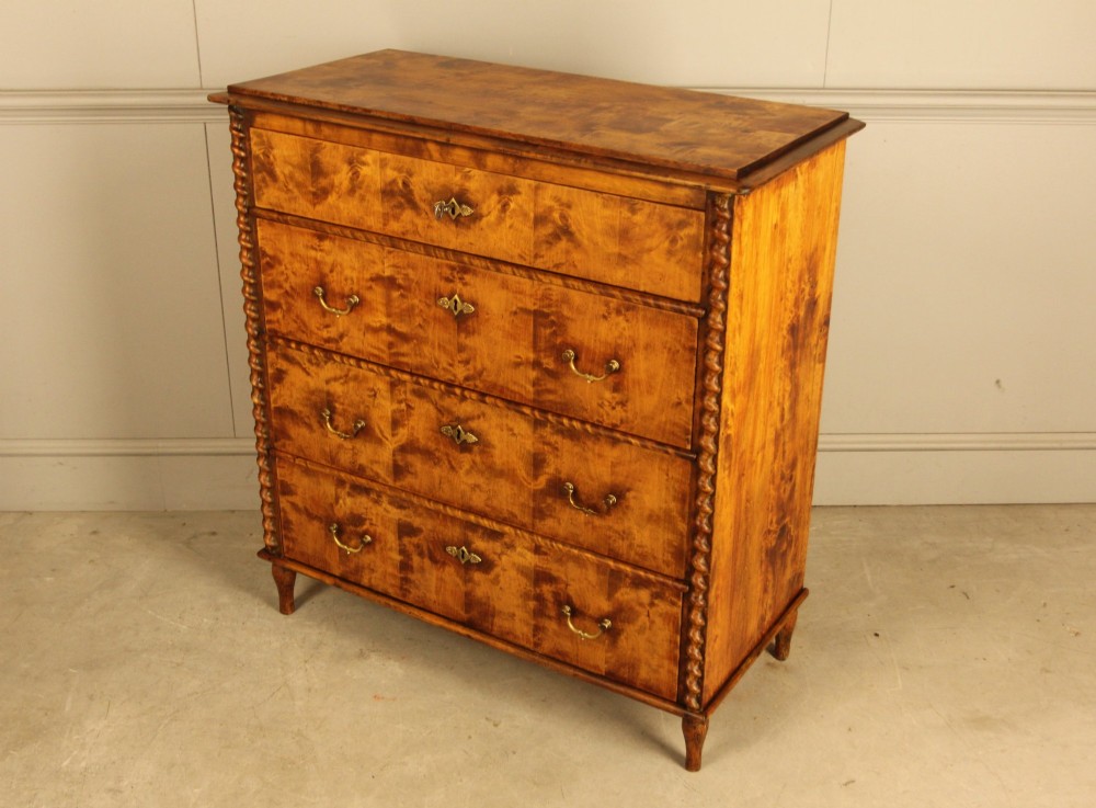 A nineteenth-century Swedish chest of drawers crafted from highly figured flame birch veneer, featuring four full-width drawers with brass drop handles, brass escutcheons, and spiral-twisted side columns. View IX
