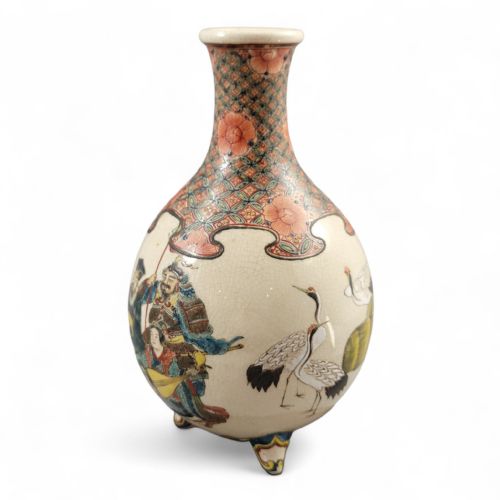 fig 2. A Japanese Meiji period Kyoto Satsuma earthenware miniature vase resting on three small feet, featuring hand-painted figures of the Seven Gods of Good Fortune set against a cream crackle glaze background.