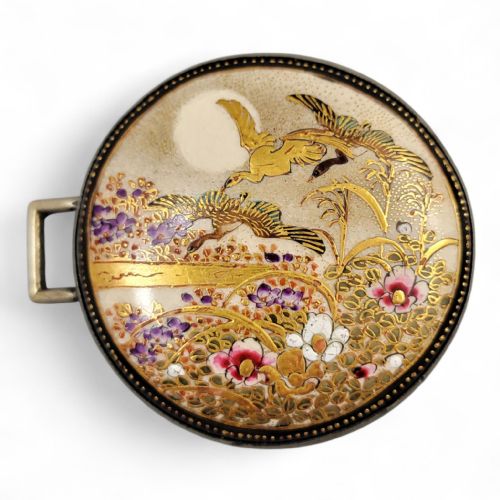 fig 1. A pair of circular Japanese Kyo-Satsuma belt buckle halves set in silver frames, decorated with intricate hand-painted birds and flowers on a cream crackle-glazed background.