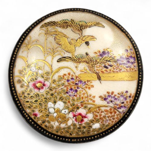 fig 2. A pair of circular Japanese Kyo-Satsuma belt buckle halves set in silver frames, decorated with intricate hand-painted birds and flowers on a cream crackle-glazed background.