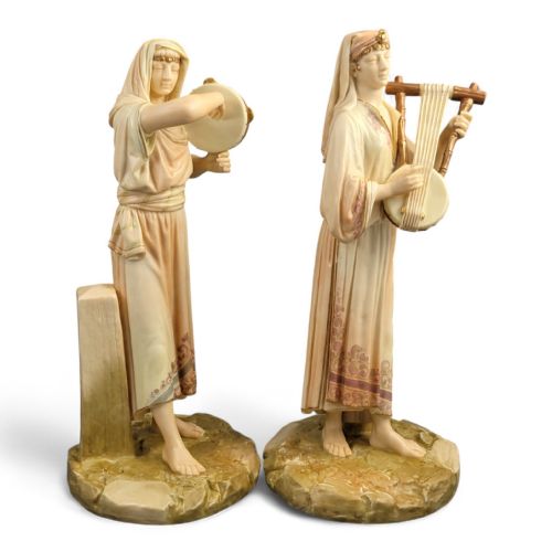 fig 1. A pair of Victorian Royal Worcester porcelain figures depicting Egyptian musicians with detailed draped robes and musical instruments on naturalistic bases.