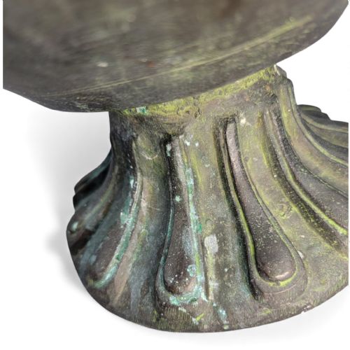 fig 2. An antique dark bronze Indian aftaba ewer featuring an engraved bulbous body, a creature-shaped spout, a fluted base, and a Makara handle.